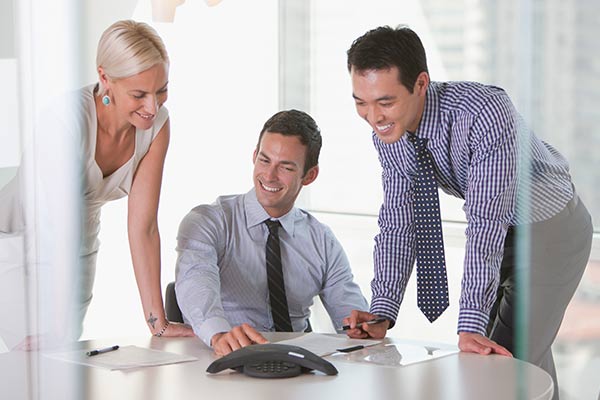 A woman and two men happily sitting on a conference call