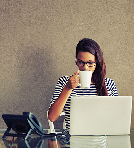 Woman sitting at her computer waiting for a conference call